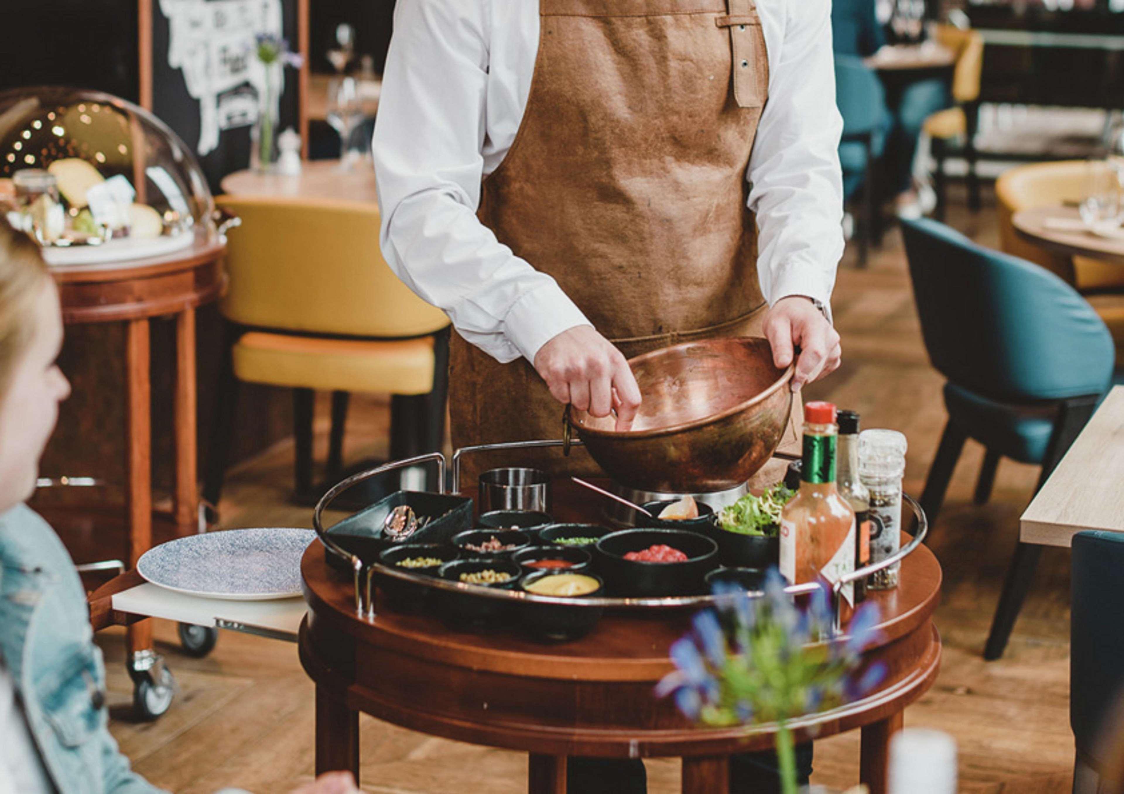 Hilton The Hague Haia Exterior foto A server prepares a dish at a restaurant